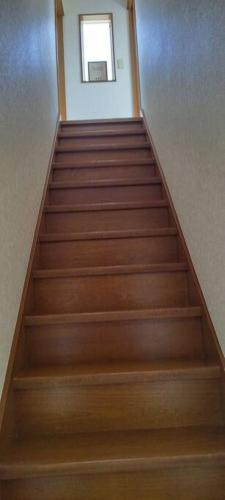 an empty staircase with wooden stairs in a building at はうす41マイルズ in Katakai
