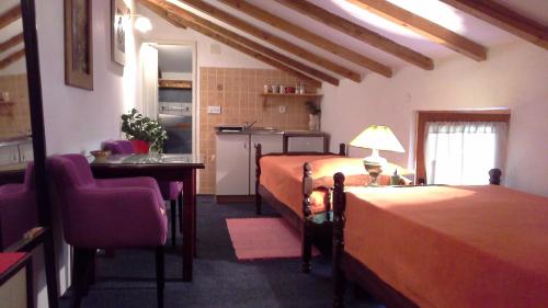 a hotel room with two beds and a kitchen at Studios Kono in Kotor