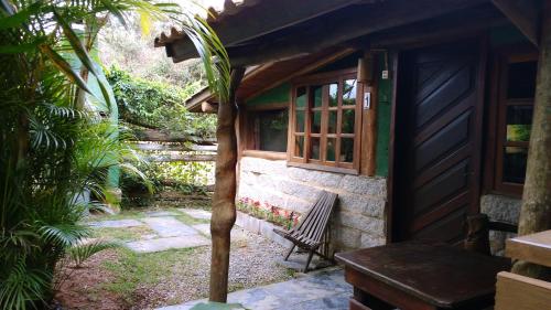 a bench sitting outside of a house with a window at Morada Amazona in Praia do Rosa