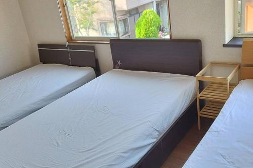 a room with two beds and a window at はうす41マイルズ in Katakai