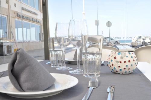 a table with glasses and a plate with a napkin at Hotel Mar Bravo in Nazaré