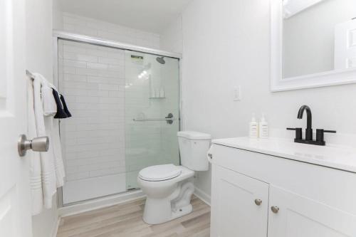 Un baño blanco con inodoro y ducha. en Sojourn Bayside 2 Bedroom, en Norfolk