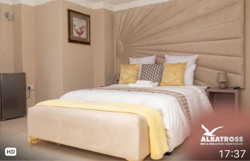 a bedroom with a large white bed with yellow pillows at The Albatross in Gaborone