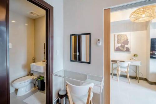 a bathroom with a toilet and a sink and a mirror at Uptown BGC in Manila