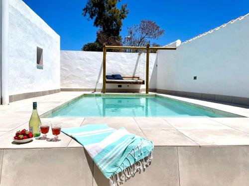 a swimming pool with a table and two glasses of wine at Minichalet El Molino 5 in Chiclana de la Frontera