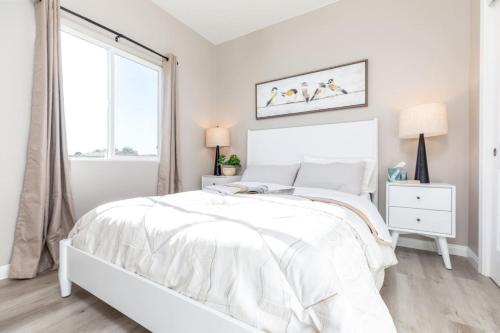 a white bedroom with a white bed and a window at Comfy and Stylish 4 Bathrooms 26 in Ridgecrest