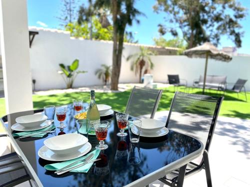 a table with plates and wine glasses on a patio at Minichalet El Molino 5 in Chiclana de la Frontera