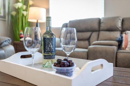 a bottle of wine and two wine glasses on a table at Comfy and Stylish 4 Bathrooms 26 in Ridgecrest