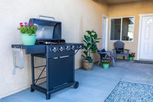 a blue barbecue grill with potted plants on a patio at Comfy and Stylish 4 Bathrooms 26 in Ridgecrest