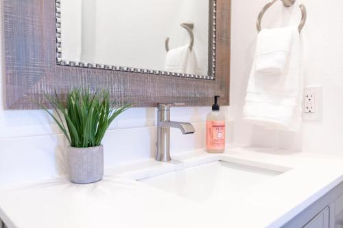 a bathroom sink with a bottle of soap and a mirror at Comfy and Stylish 4 Bathrooms 26 in Ridgecrest