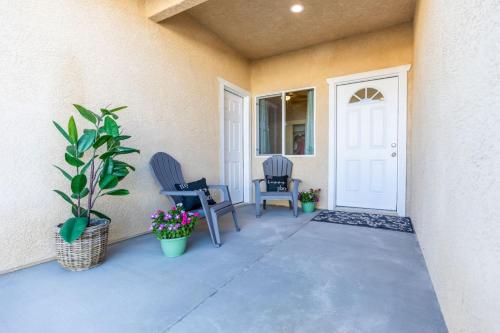 a porch with two chairs and a white door at Comfy and Stylish 4 Bathrooms 26 in Ridgecrest