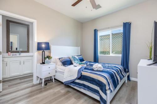 a bedroom with a blue and white bed and a window at Luxury, Style and Comfort 4 Bathrooms 21 in Ridgecrest