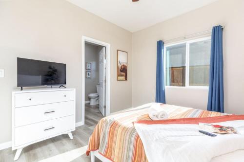 a bedroom with a bed and a dresser with a television at Luxury, Style and Comfort 4 Bathrooms 21 in Ridgecrest