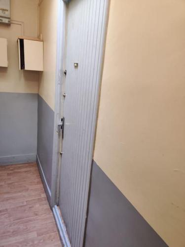 Cette chambre dispose d'un couloir avec une porte et de parquet. dans l'établissement studio cosy Paris 9, à Paris