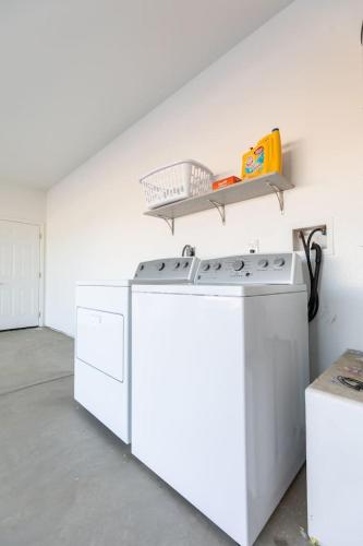 a white kitchen with a stove and a shelf at Luxury, Style and Comfort 4 Bathrooms 21 in Ridgecrest