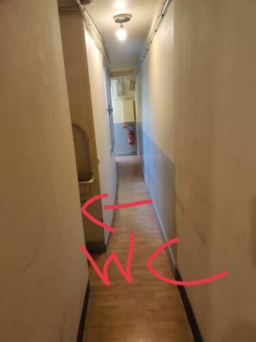 un couloir avec des écritures rouges sur le sol dans l'établissement studio cosy Paris 9, à Paris
