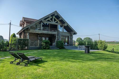 a bench sitting in the grass in front of a house at Cozy 4-Bedroom Chalet with Outdoor Spa in Zottegem in Zottegem