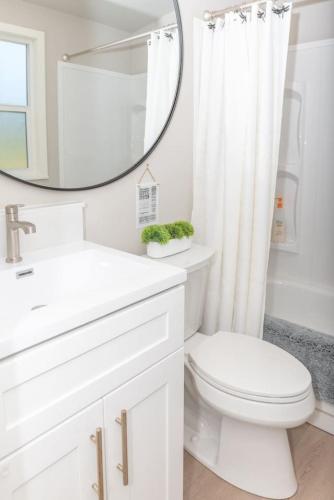 a white bathroom with a toilet and a mirror at Dragonfly Beach Retreat in Grayland