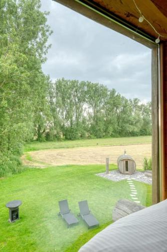 a view of a yard with two chairs and a grill at Cozy 4-Bedroom Chalet with Outdoor Spa in Zottegem in Zottegem