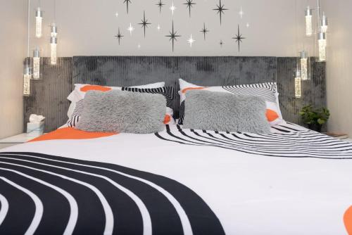 a large white bed with black and white pillows at Dragonfly Beach Retreat in Grayland