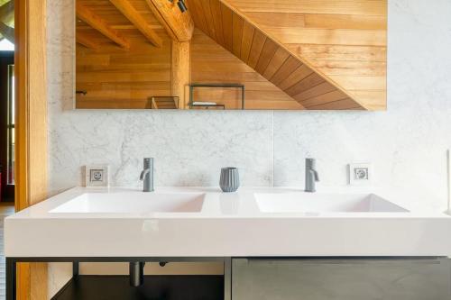 a bathroom with two sinks and a mirror at Cozy 4-Bedroom Chalet with Outdoor Spa in Zottegem in Zottegem