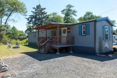 a tiny house with a porch and a deck at Dragonfly Beach Retreat in Grayland