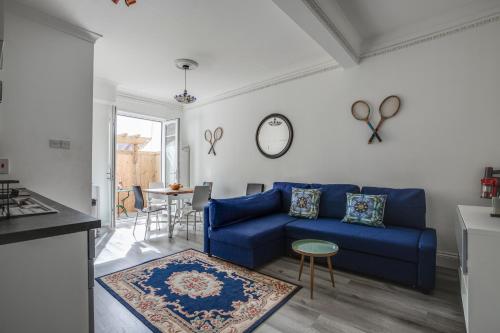 a living room with a blue couch and a table at Bright 2-Bed in Wimbledon - 3 min Walk to Tube in London