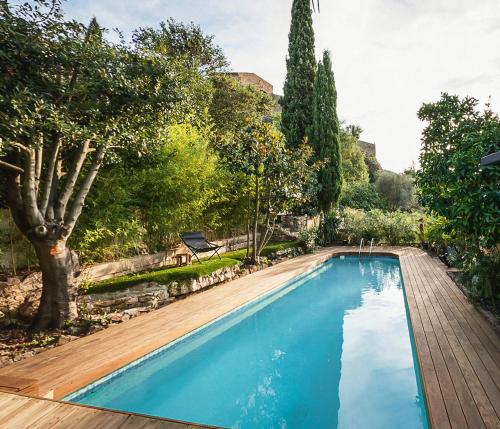 - une piscine dans une cour avec une terrasse en bois dans l'établissement Au calme, piscine et spa privés, à Roquebrune-sur Argens