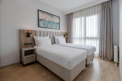 a hotel room with two beds and a window at Antwell Suites in Istanbul