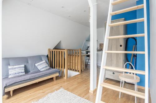 - un salon avec un canapé et une échelle dans l'établissement La Cabane Malouine, à Saint-Malo