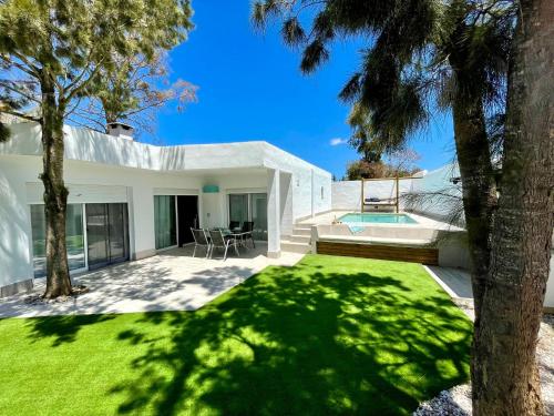 a white house with a yard and a swimming pool at Minichalet El Molino 5 in Chiclana de la Frontera