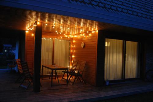 a patio with a table and chairs and lights at Apartma Bazilika in Topolšica