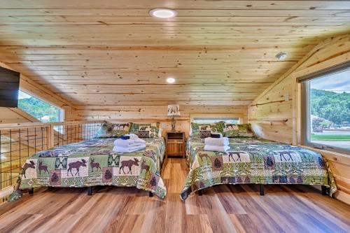 two beds in a room with wooden walls at Retreat on the Lake in Hiawassee