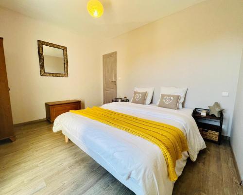- une chambre avec un grand lit blanc et une couverture jaune dans l'établissement La villa Louca, à Saint-Saturnin-lès-Apt