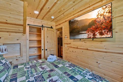 a bedroom of a cabin with a tv on the wall at Retreat on the Lake in Hiawassee