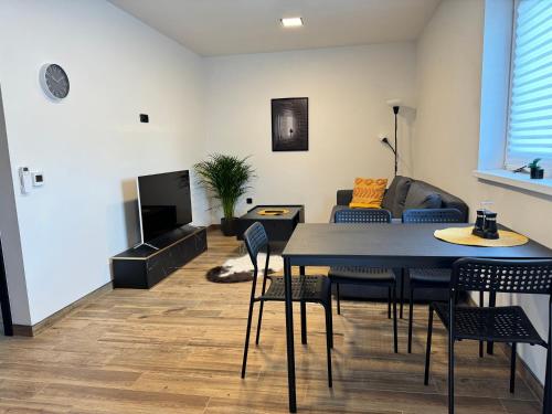 a living room with a table and chairs and a couch at j ONE Apartmány in Pardubice