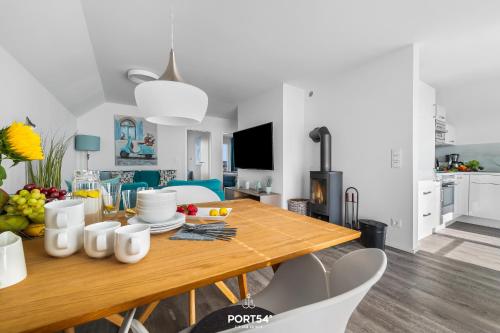 a kitchen and living room with a wooden table and chairs at Ferienwohnung La Mer Olpenitz in Olpenitz