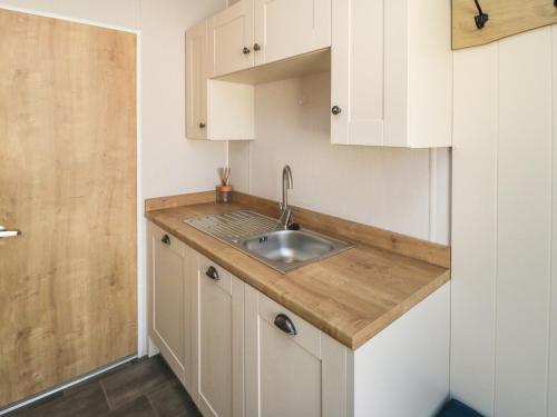 a kitchen with white cabinets and a sink at 28 Finch in Scarborough