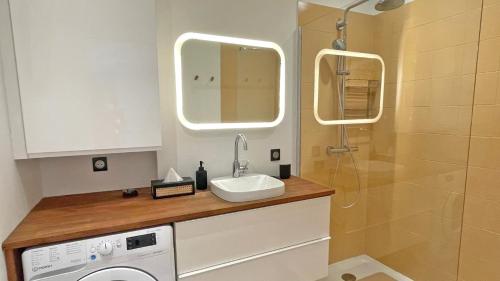 une salle de bain avec un lavabo et une machine à laver dans l'établissement Victor Marguerite, à Sainte-Maxime