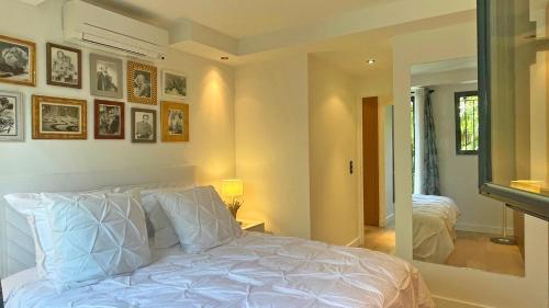 une chambre avec un lit blanc et un miroir dans l'établissement Victor Marguerite, à Sainte-Maxime