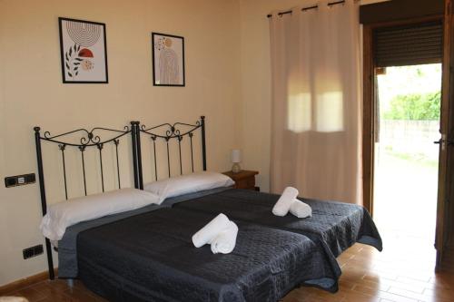 a bedroom with a bed with two towels on it at La Muralla de Gredos Hotel Rural in Madrigal de la Vera