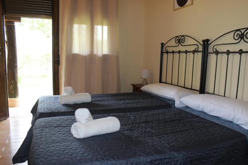 two beds in a room with towels on them at La Muralla de Gredos Hotel Rural in Madrigal de la Vera