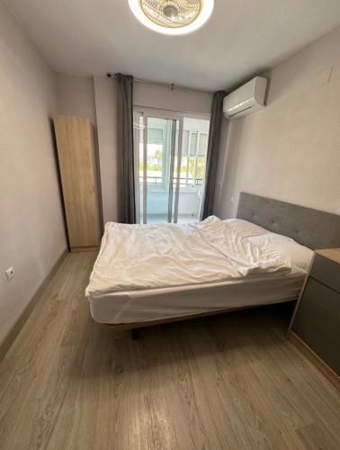 a bedroom with a bed in a room with a window at Marina in Torrevieja