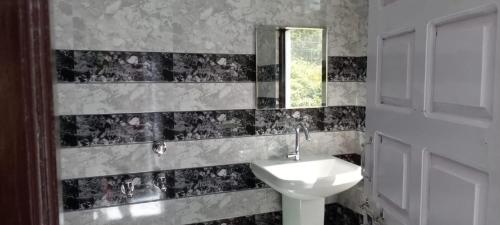 a bathroom with a sink and a mirror at Vamoose Maa Bhawani Munsiyari in Munsyari