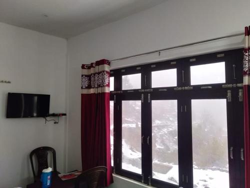 a room with a window with a mountain view at Vamoose Maa Bhawani Munsiyari in Munsyari