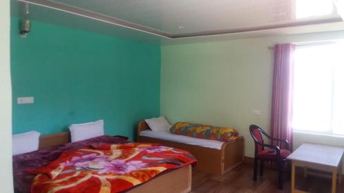 a bedroom with a bed and a couch and a table at Vamoose Maa Bhawani Munsiyari in Munsyari