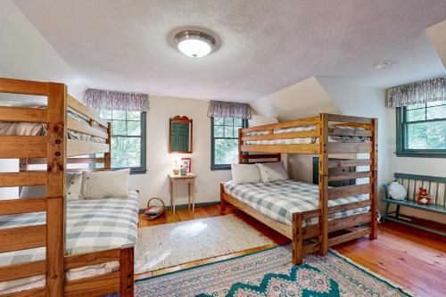 1 Schlafzimmer mit 2 Etagenbetten und einem Teppich in der Unterkunft Dog Cove Cottage in Center Harbor