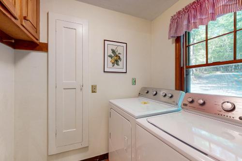eine Waschküche mit einer Waschmaschine und einem Fenster in der Unterkunft Dog Cove Cottage in Center Harbor