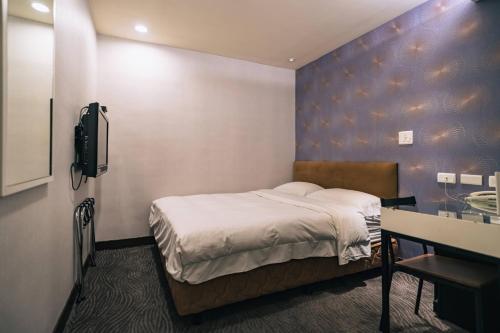 a bedroom with a bed and a sink in it at Hotel Puri in Taipei