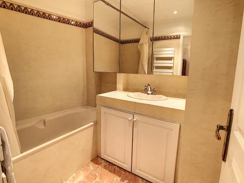 une salle de bain avec un lavabo et une baignoire dans l'établissement Splendide appartement face Croisette - SOU3528, à Cannes